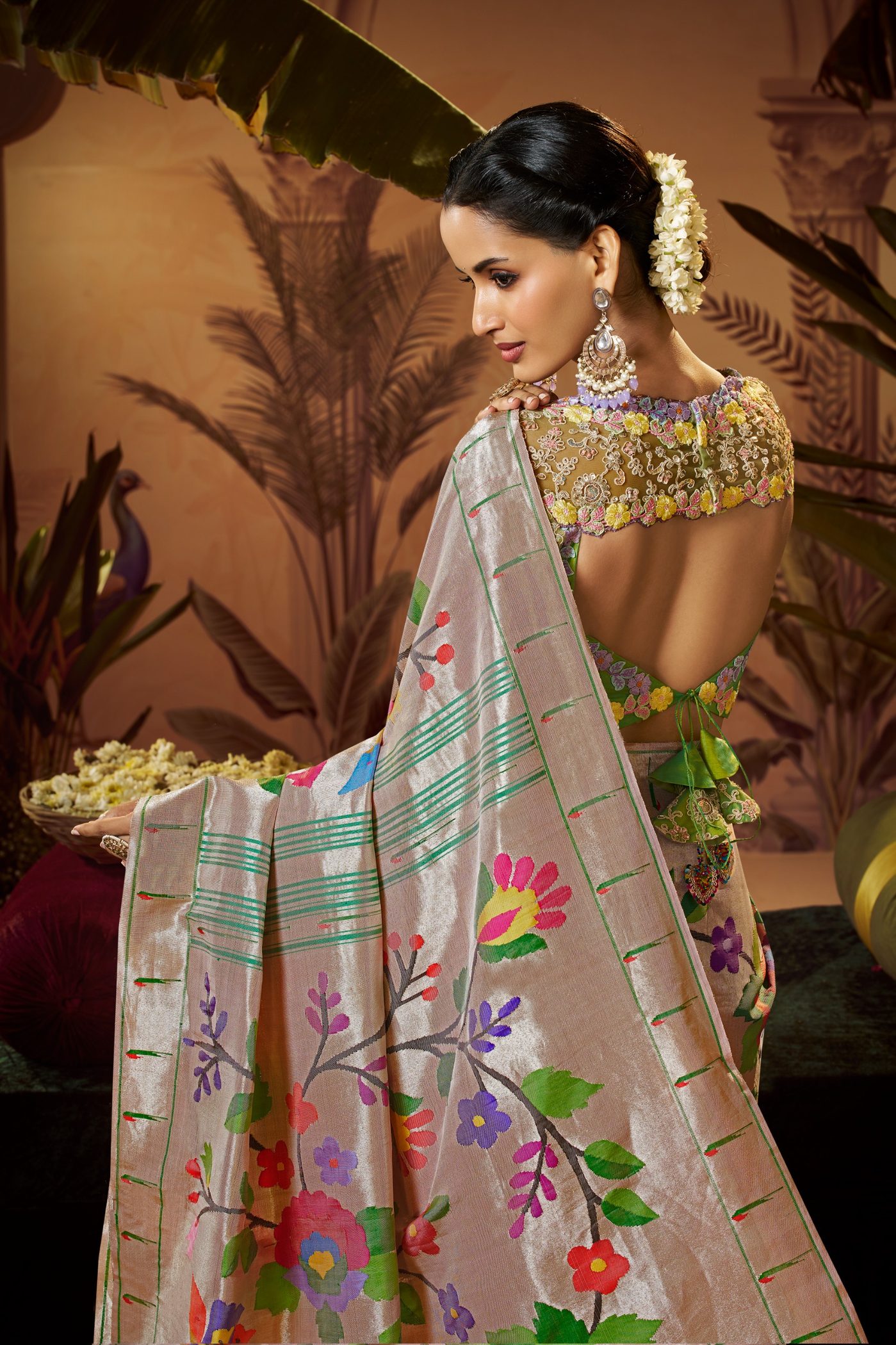 Back view of a silver grey Paithani saree pallu with multicoloured floral buttas and a gold blouse