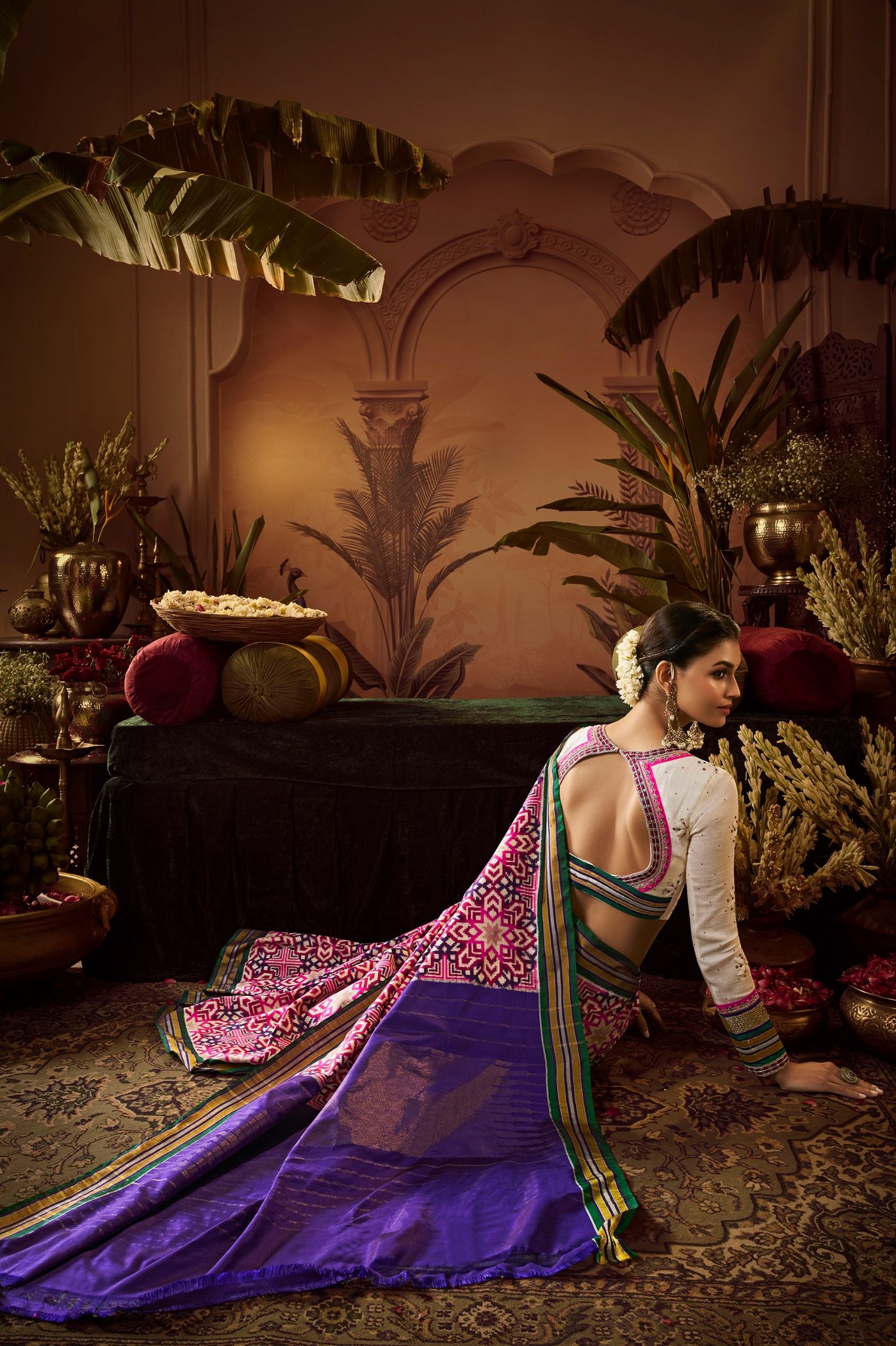 Violet Patola saree with a rose and gold pallu spread out on the floor of a courtyard set