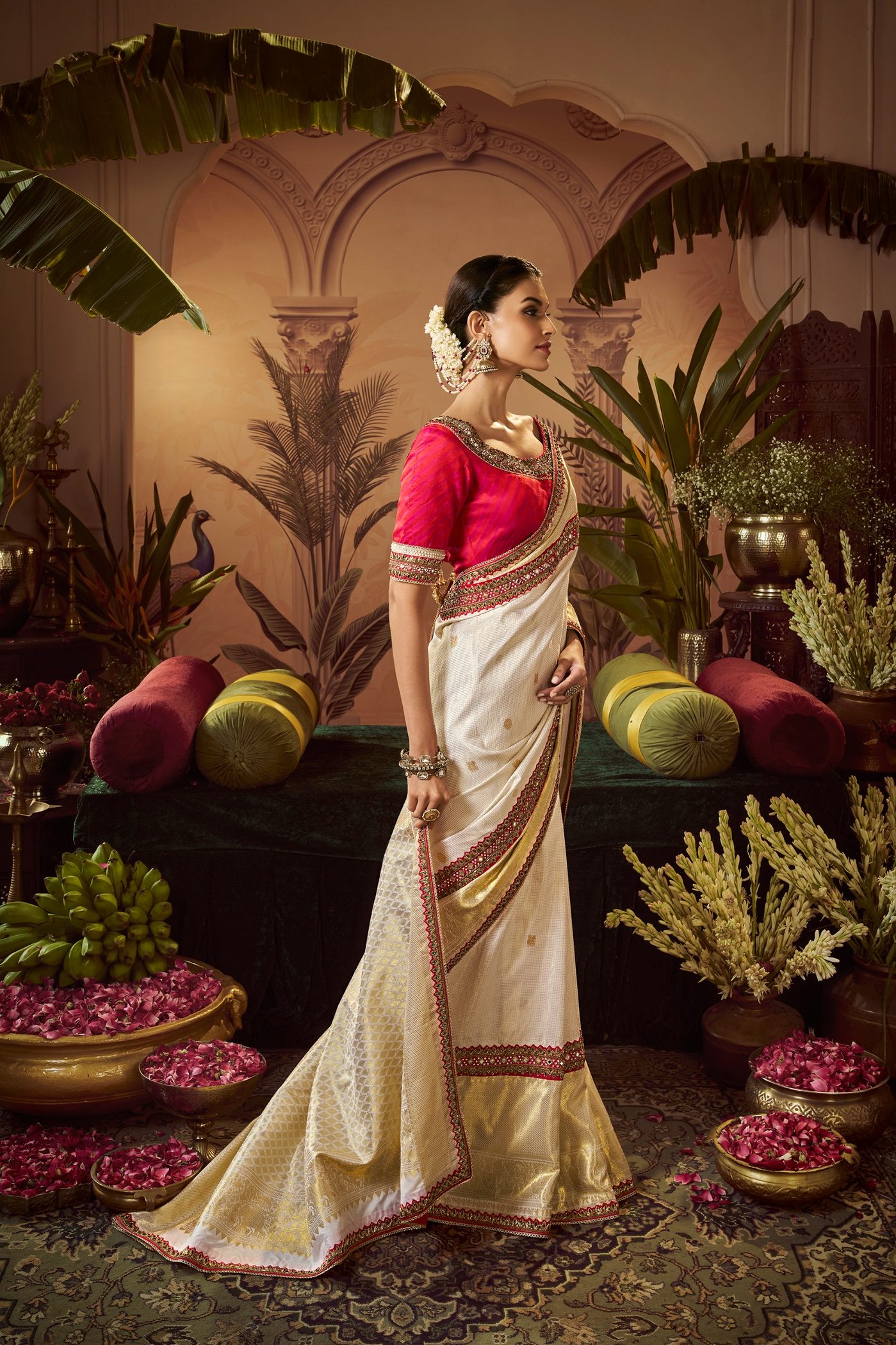 Cream tissue Kanjivaram saree with gold zari and a deep red korvai border, styled with a red blouse