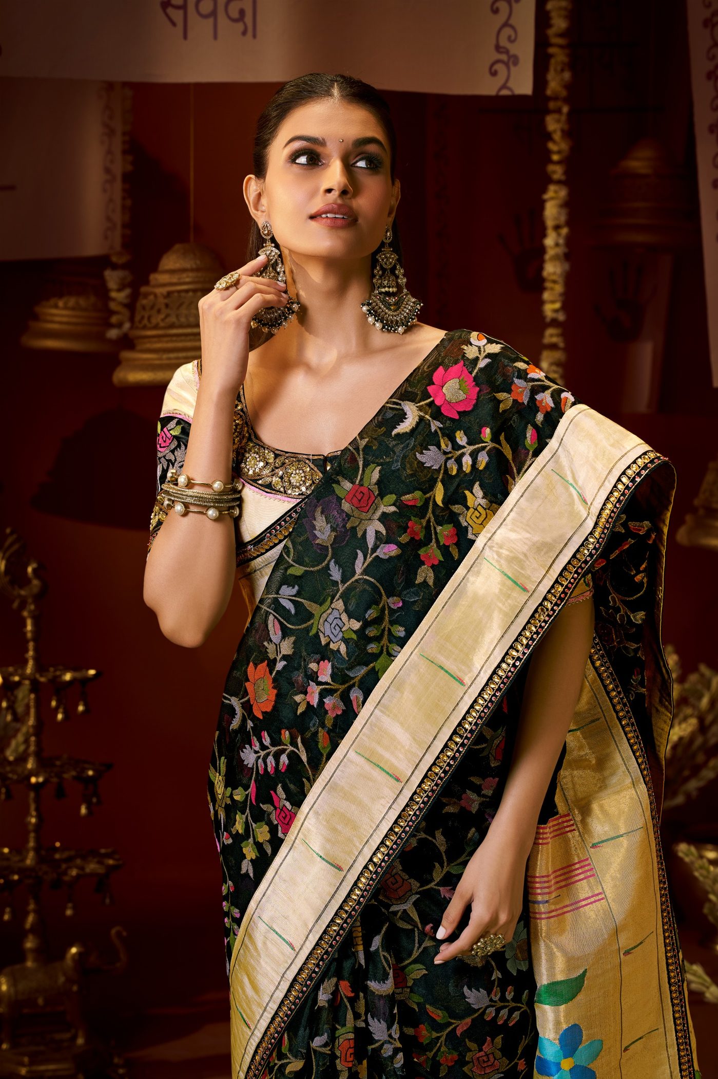 Black Paithani saree with an ivory floral woven border and gold zari, worn with statement earrings